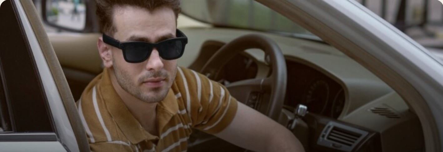 A man wearing Mondra, stepping out of a car
